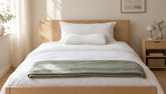 Nackenstützkissen mit Wellenform und Kopfkissen auf einem hellen Bett