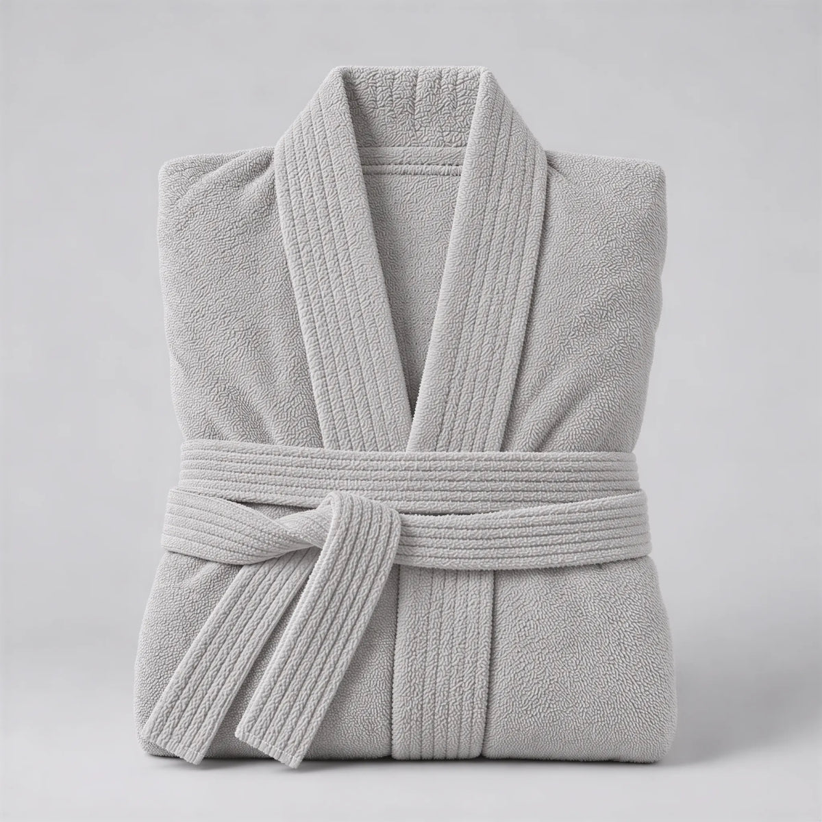 Bademantel hellgrau aus Walkfrottee in Kimono-Form, gefaltet auf hellgrauem Hintergrund