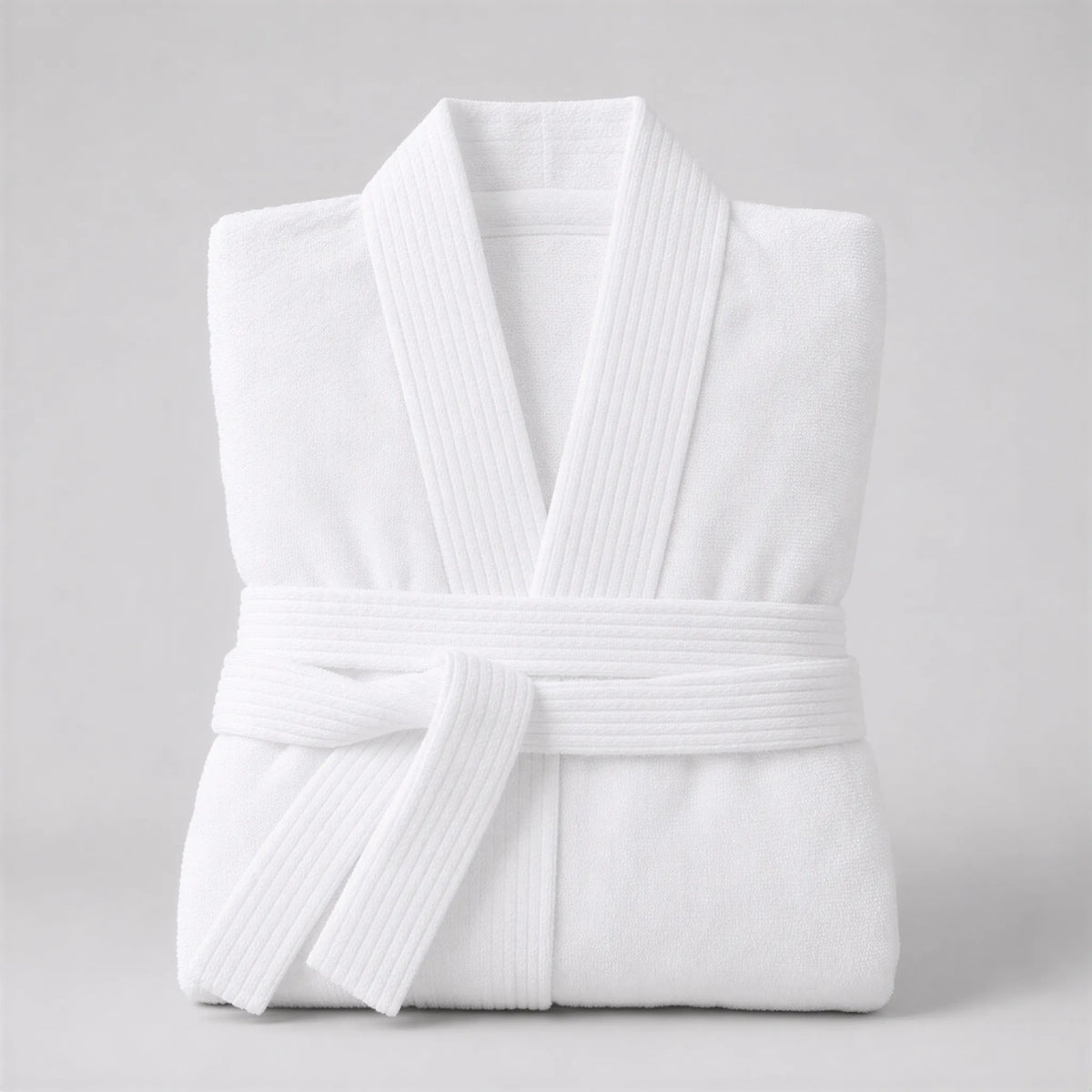 Bademantel weiß in Kimono-Form, gefaltet auf hellgrauem Hintergrund