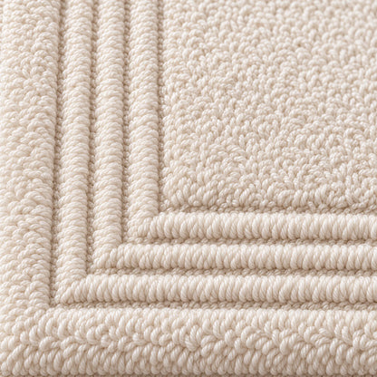 Nahaufnahme der festen Zwirnfrottee-Schlingen mit Stäbchenbordüre – Badematte creme beige