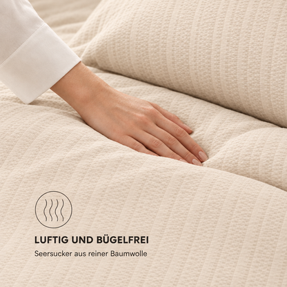 Bettwäsche-Set Seersucker champagner – Hand auf der Bettdecke zeigt die Seersucker-Struktur